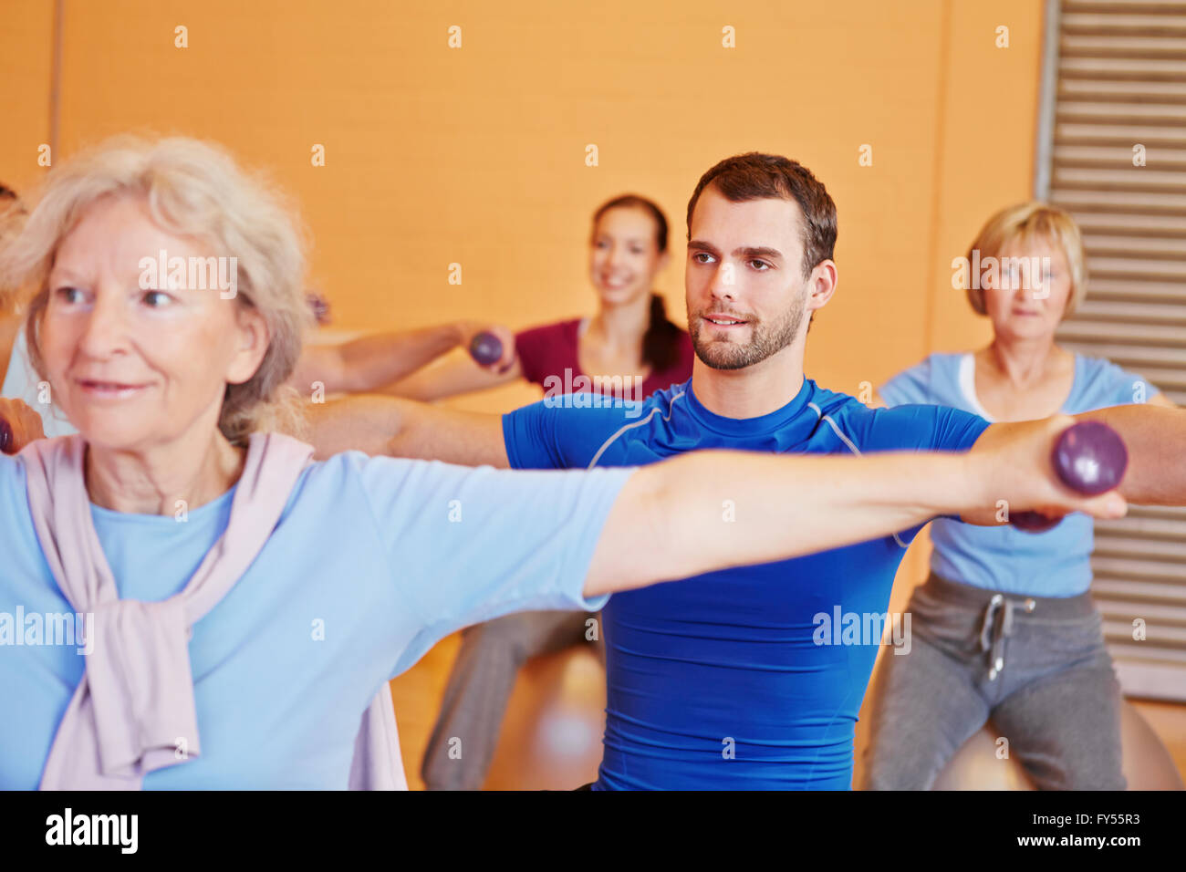 Giovane uomo il sollevamento pesi in classe di allenamento in palestra Foto Stock Giovane uomo il sollevamento pesi in classe di allenamento in palestra Foto Stock
