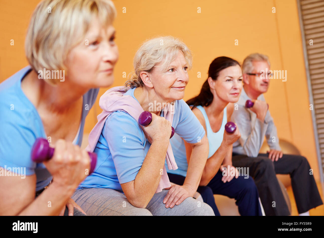 Gruppo di anziani facendo sport senior nel centro fitness con manubri Foto Stock