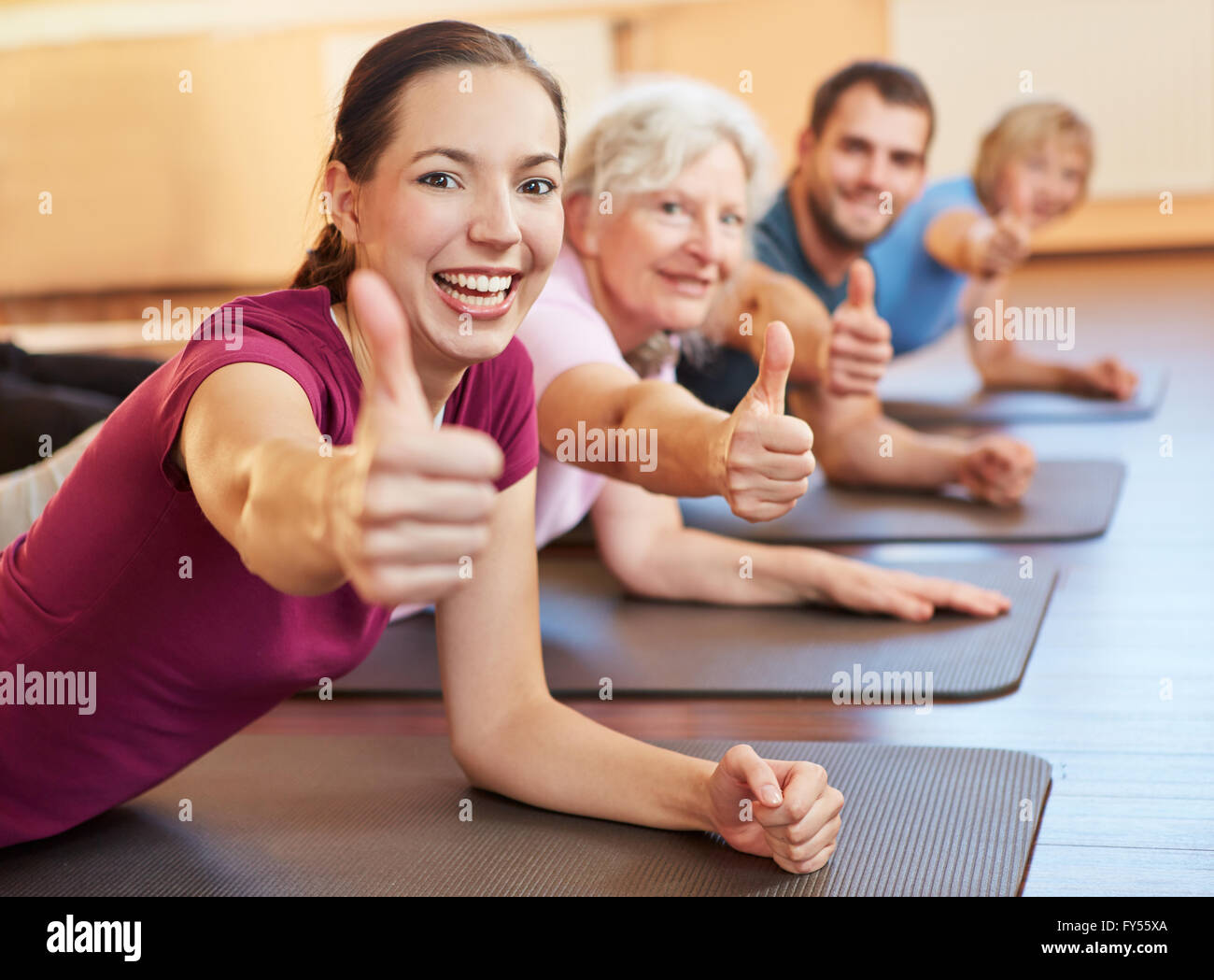 Felice group holding i pollici in su in un centro fitness Foto Stock