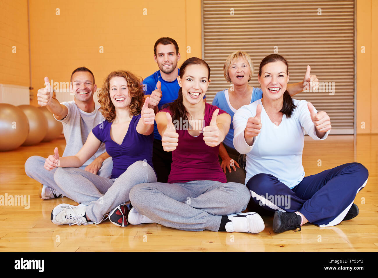 Il tifo sports group holding pollice in alto in un centro fitness Foto Stock