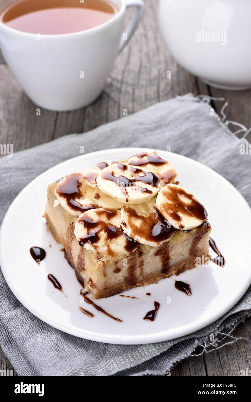 Banan cheese cake con lo sciroppo al cioccolato e pezzo di banana Foto Stock