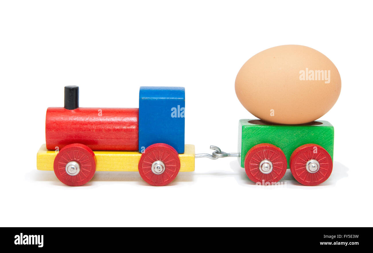 In legno colorato modello ferroviario con un uovo su un carro merci, isolato Foto Stock