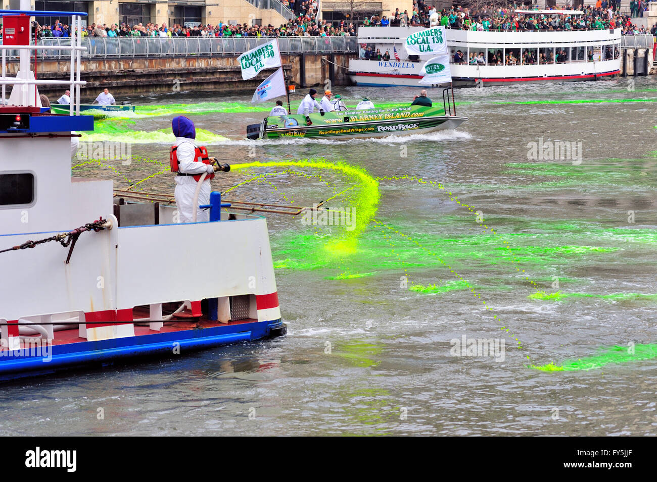 Gli equipaggi di tintura del Chicago River Green per la festa di San Patrizio vacanza come linea di migliaia di banche a guardare. Chicago, Illinois, Stati Uniti d'America. Foto Stock