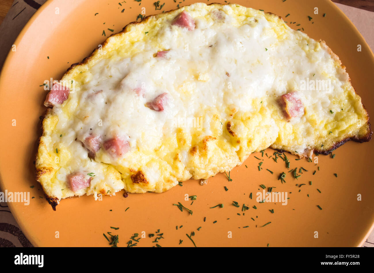 Appena tostato frittata con prosciutto e formaggio su una piastra. Tema colazione Foto Stock