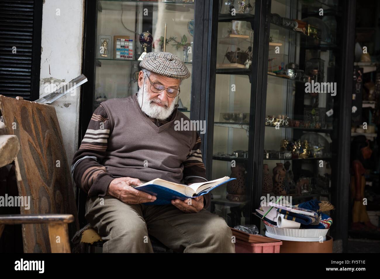 (160422) -- Il Cairo, 22 aprile 2016 (Xinhua) -- Mahamoud Sabry, un 81-anno-vecchio uomo d affari, legge il Corano davanti il suo negozio di souvenir al Cairo, Egitto, 9 marzo 2016. Mahamoud Sabry persiste nella lettura di tutti i giorni. Oltre alla lettura di finitura tutto il Corano ogni 6 giorni, egli legge anche libri di poesia, della storia e della politica. Xxi Giornata Mondiale del libro e del Copyright arriverà il sabato. "Un libro è un legame tra il passato e il futuro. Si tratta di un ponte tra le generazioni e tra le culture. Essa è una forza per la creazione e la condivisione di sapienza e conoscenza." ha affermato il direttore generale dell'UNESCO Irina Bokova. A poppa Foto Stock