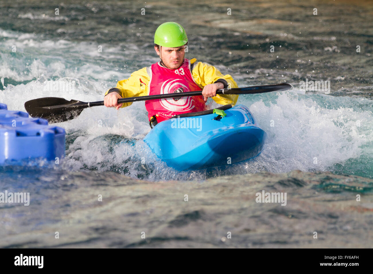 Giovane uomo maschio sguazzare un kayak in acqua bianca. L'uomo è la remata verso la telecamera. Foto Stock