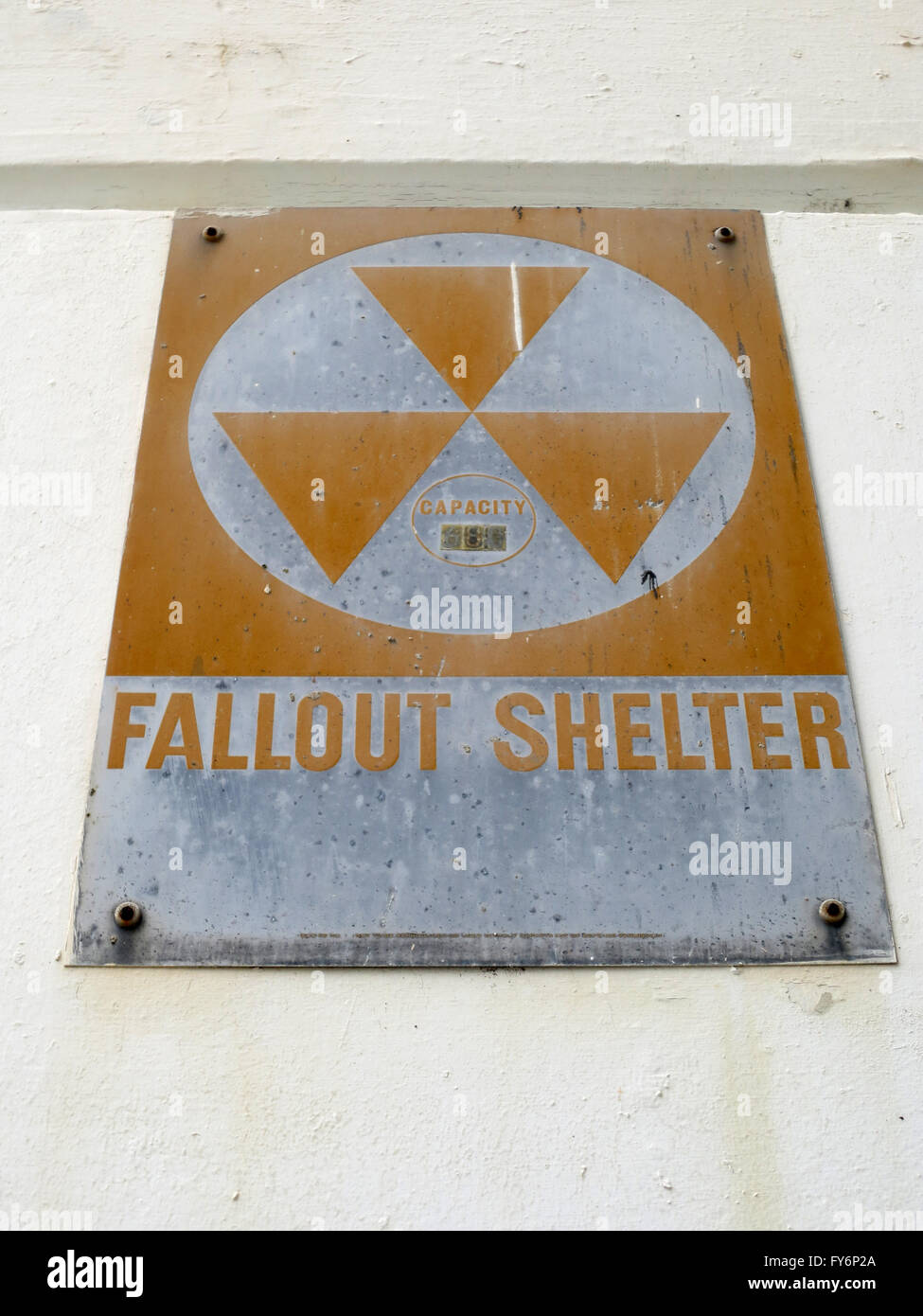 Vecchio Fallout Shelter segno dall'epoca della guerra fredda lentamente arrugginisce come esso si blocca sulla parete. Foto Stock