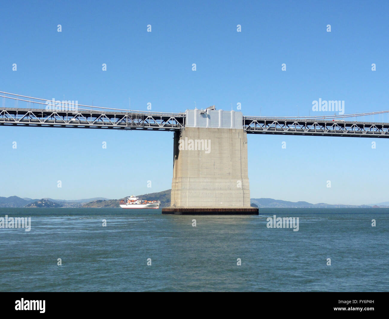 Centro di San Francisco lato del ponte della baia con una grande nave da carico a distanza in un giorno chiaro. Foto Stock