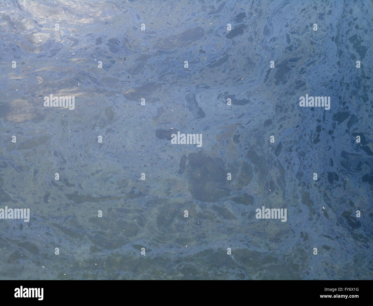 Slick di inquinamento di olio sulla superficie di acqua prendere in una imbarcazione marina. Foto Stock