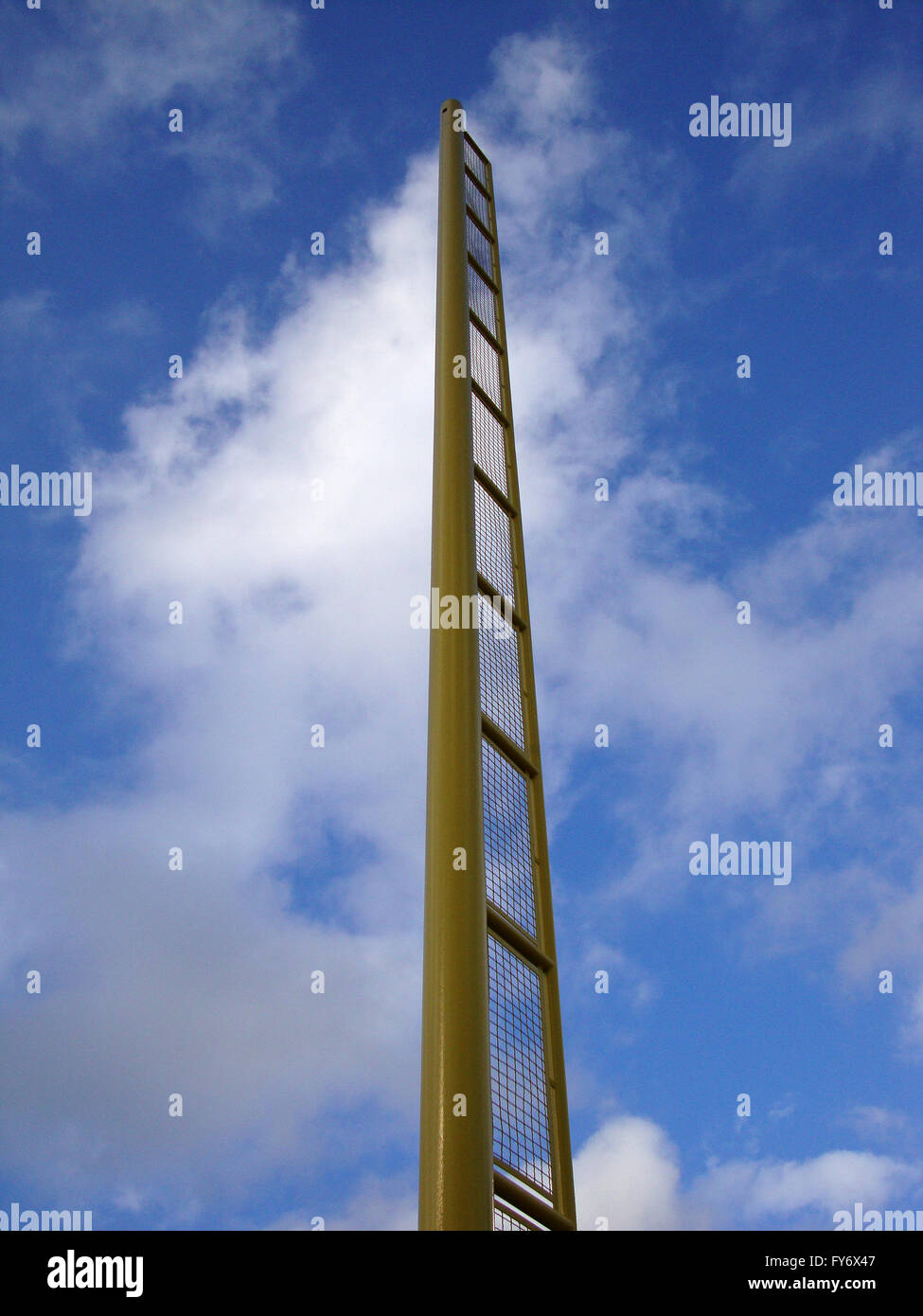 Giallo fallo Pole contro nuvoloso cielo blu Foto Stock