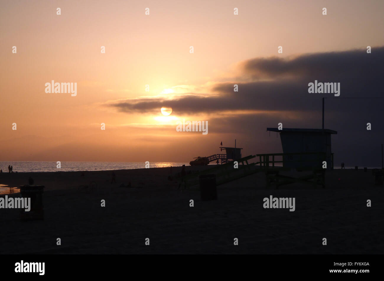 Due Venice Beach Lifeguard towers, spiaggia carrello e persone sagome al tramonto in California. Foto Stock