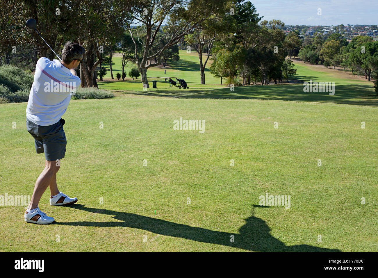 Un giovane giocatore di golf in posizione di finitura, dopo aver toccato un tee-shot Foto Stock