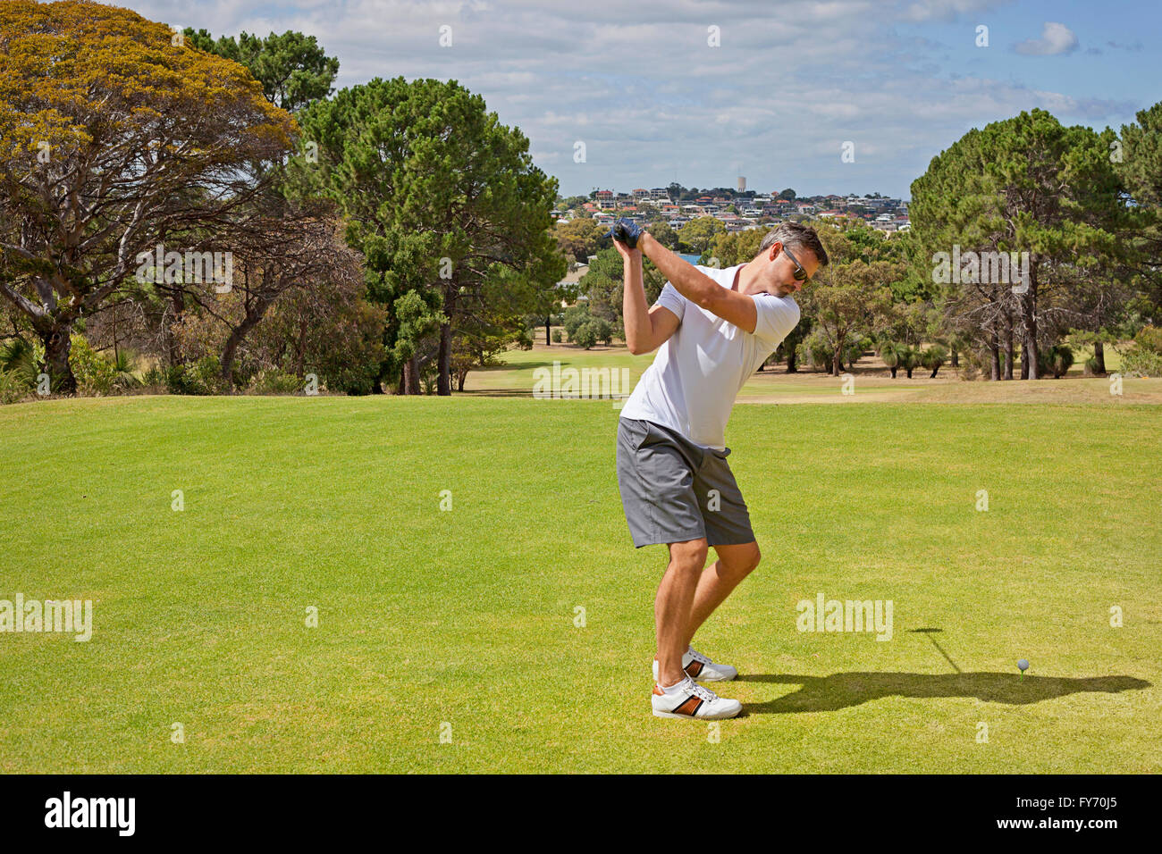 Un giocatore di golf in posizione di partenza prima di colpire il tee-shot Foto Stock