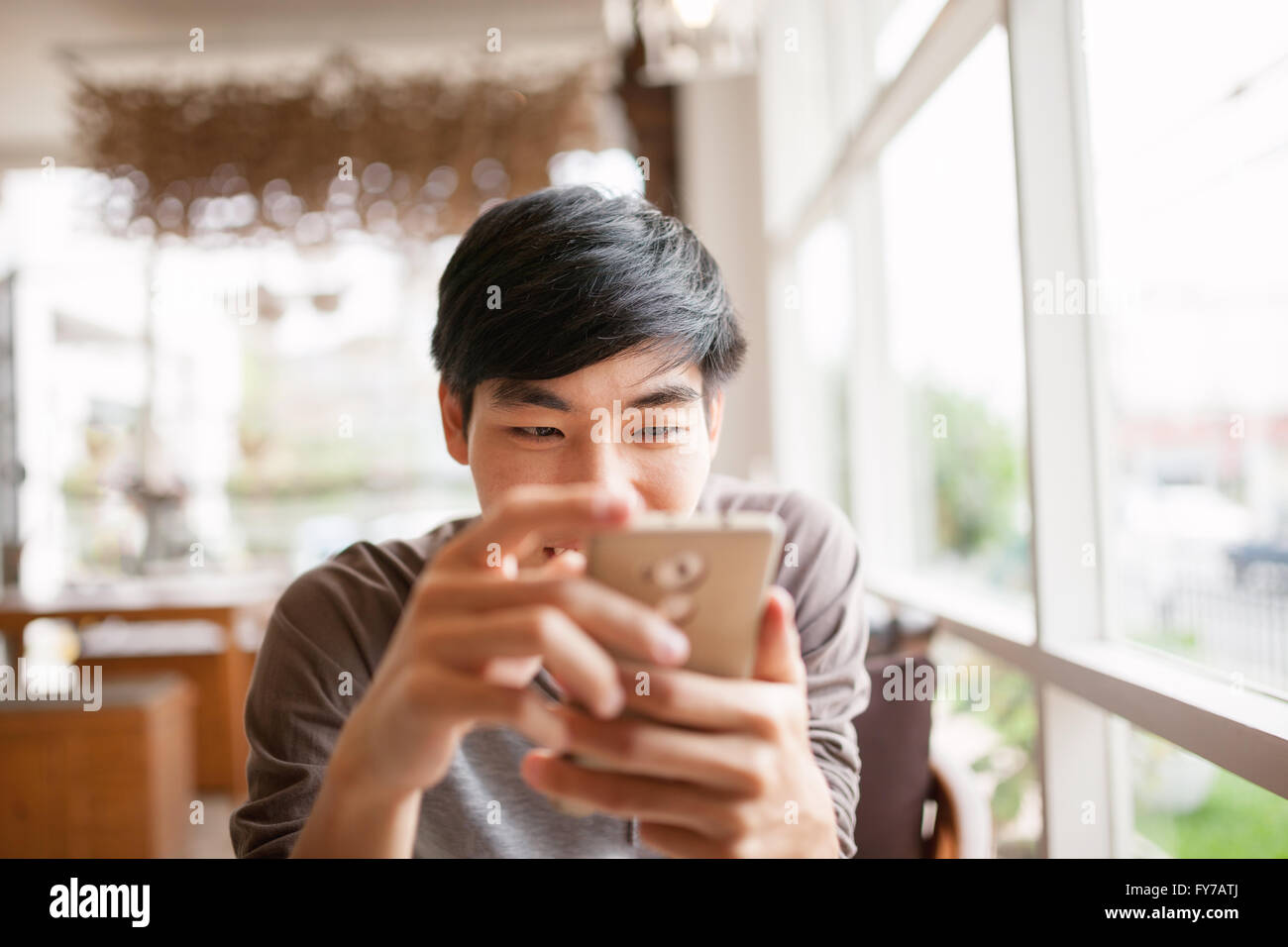 Home, tecnologia e concetto di internet - uomo sorridente utilizza lo smartphone per la chat online o shopping . Foto Stock