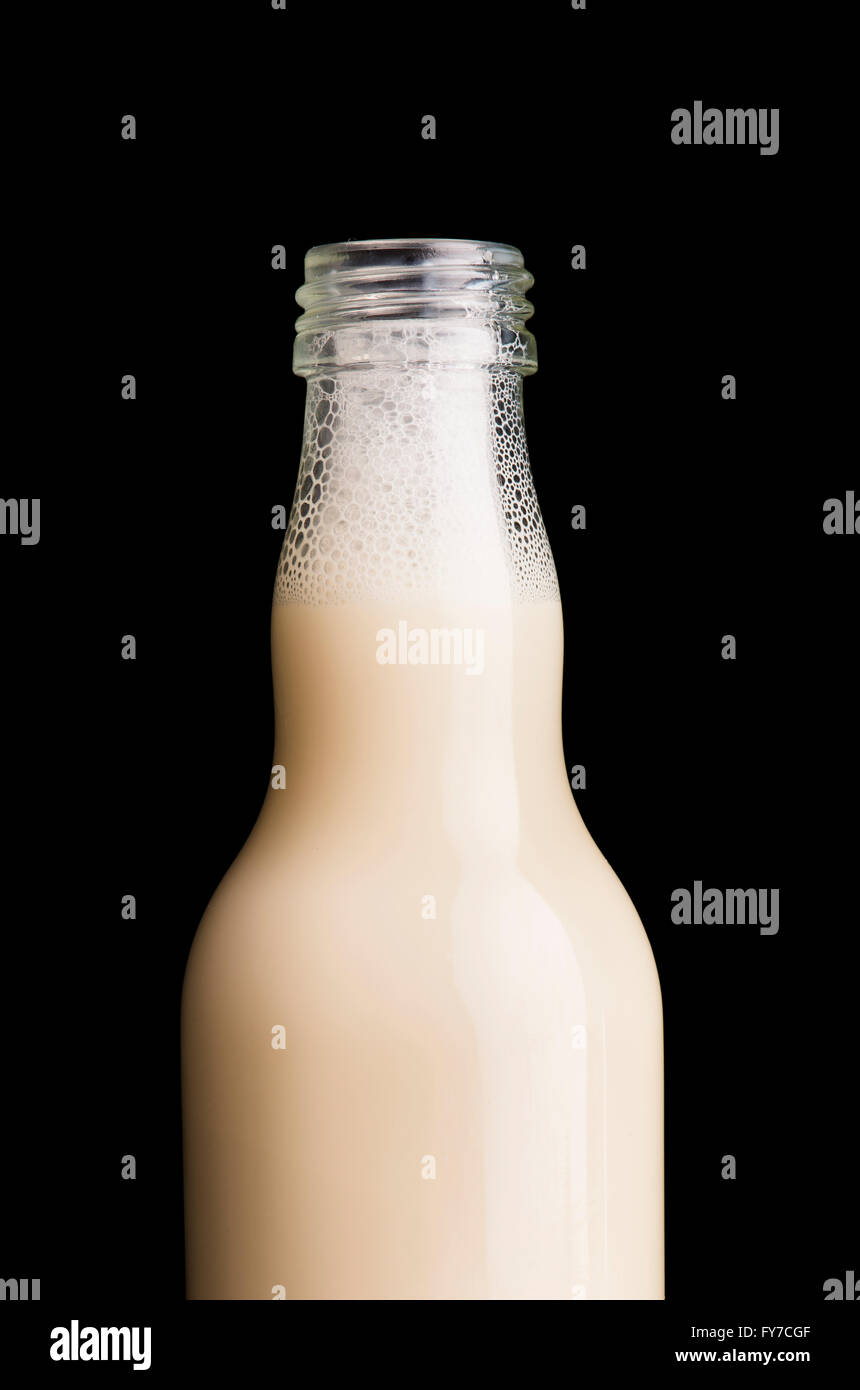 Il latte di soia in una bottiglia di vetro, vicino. Sfondo nero. Foto Stock