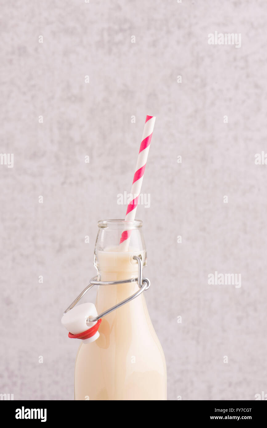 Latte di avena in un flacone di vetro con striped cannuccia in stretta verso l'alto. Foto Stock