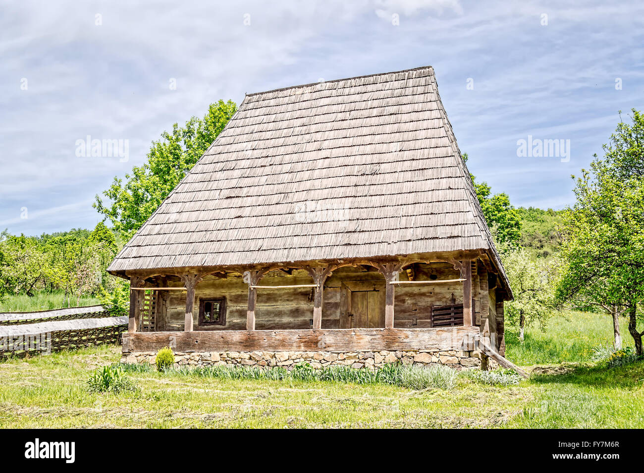 Vecchia casa tradizionale fatta di legno con un tessuto doppio recinto di salice e righe di erba tagliata nella parte anteriore. Foto Stock