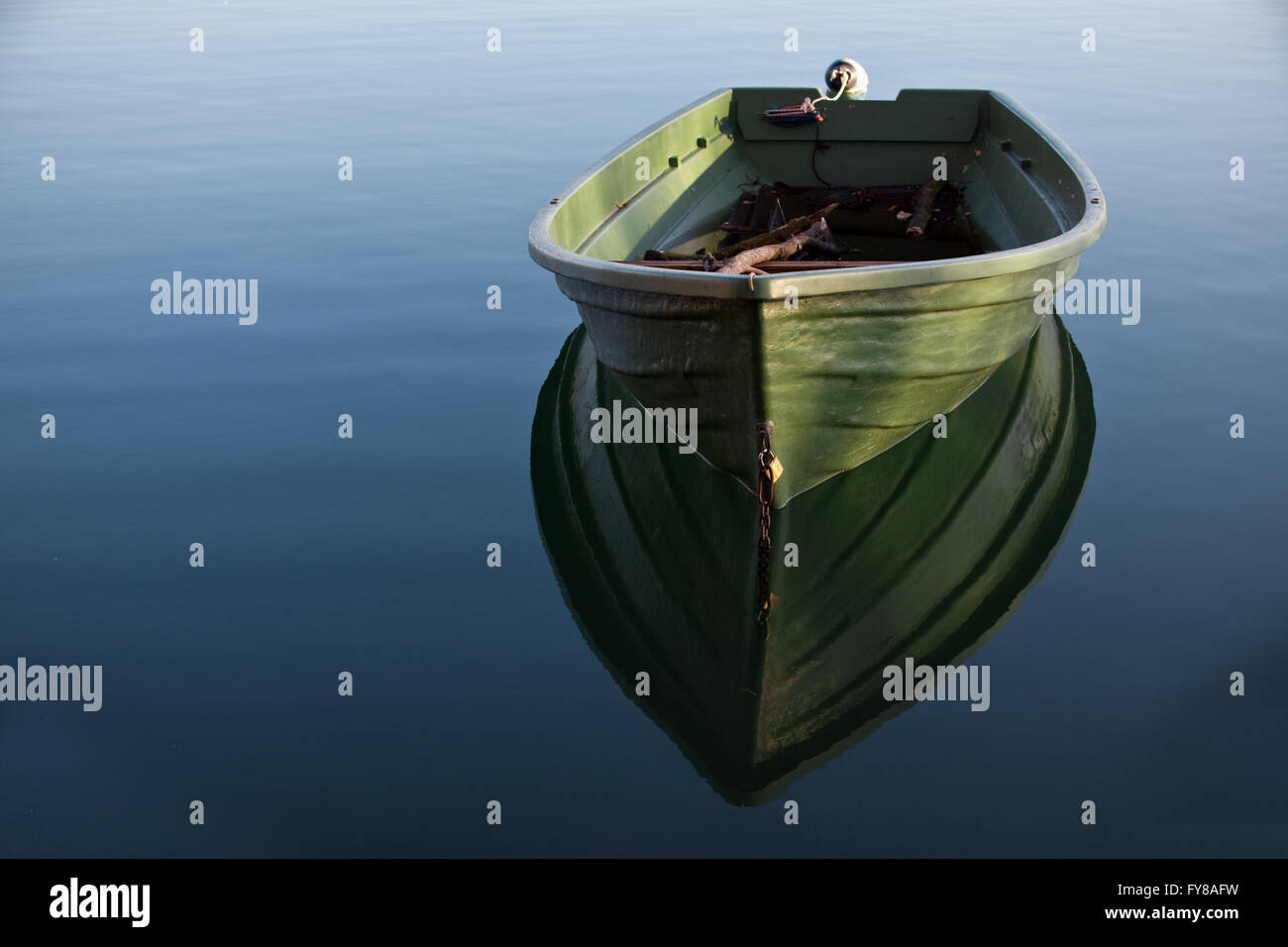 Fila singola barca sul lago con riflesso nell'acqua Foto Stock