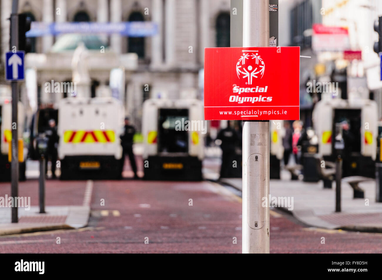 PSNI poliziotti armati con blocco landrovers off Donegal luogo a Belfast, dove una Special Olympics segno viene visualizzato. Foto Stock