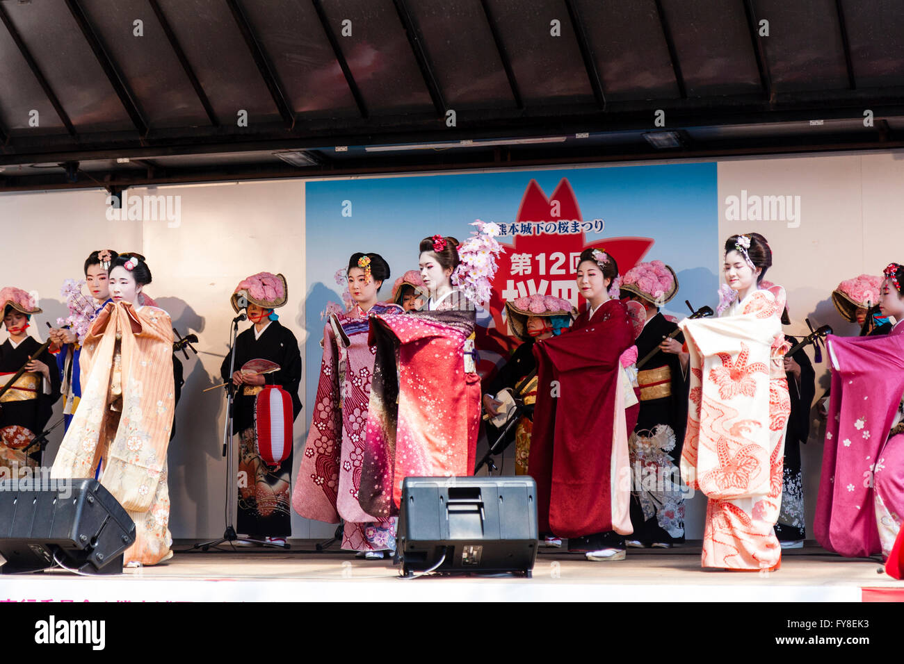 Giapponese primavera Kumamoto Cherry Blossom Festival, spettacolo teatrale, quattro geisha in kimono dancing, con fila di musicisti in costume tradizionale dietro. Foto Stock