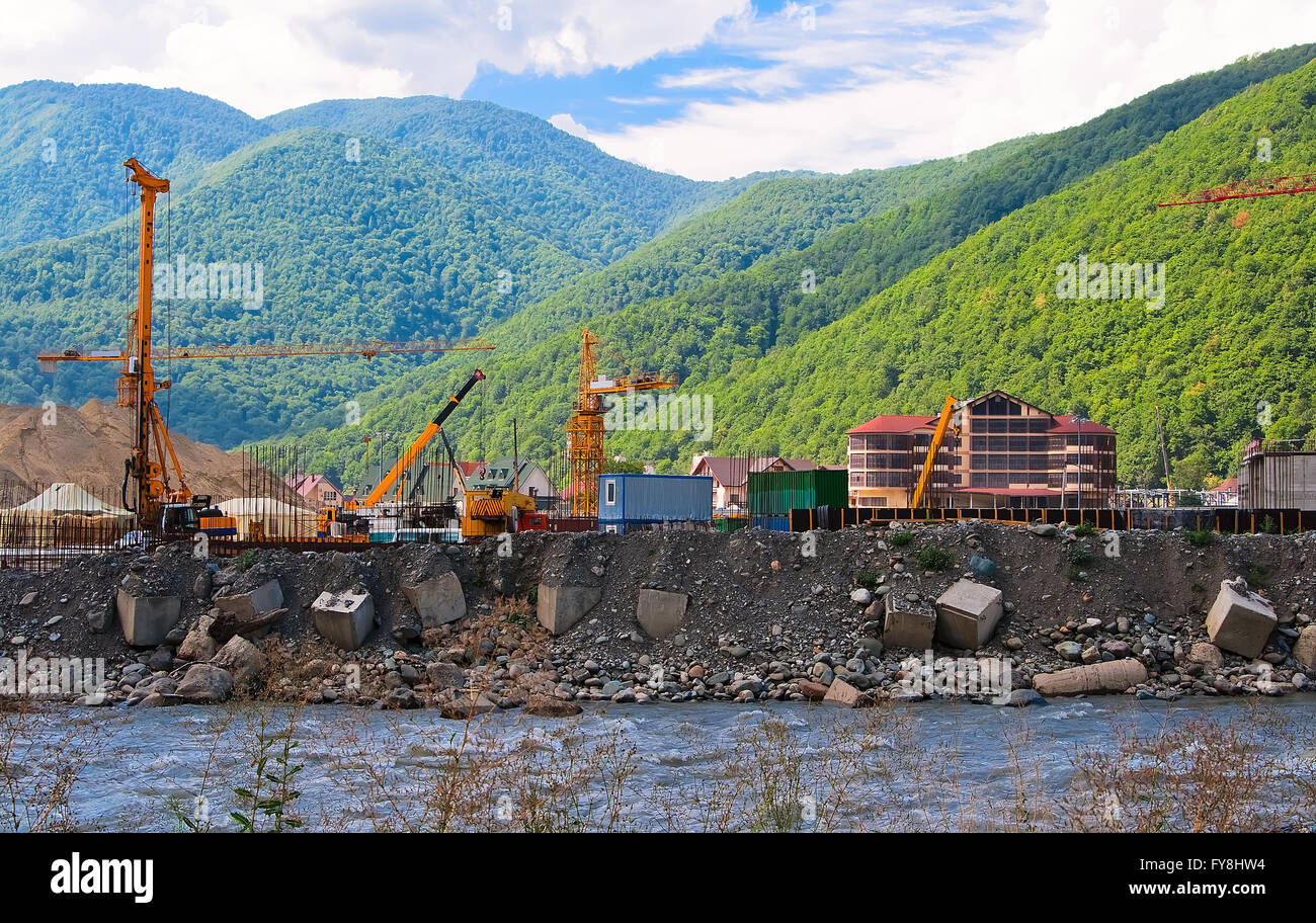 Attrezzature da costruzione in corrispondenza di un sito in costruzione sulle rive del fiume Foto Stock