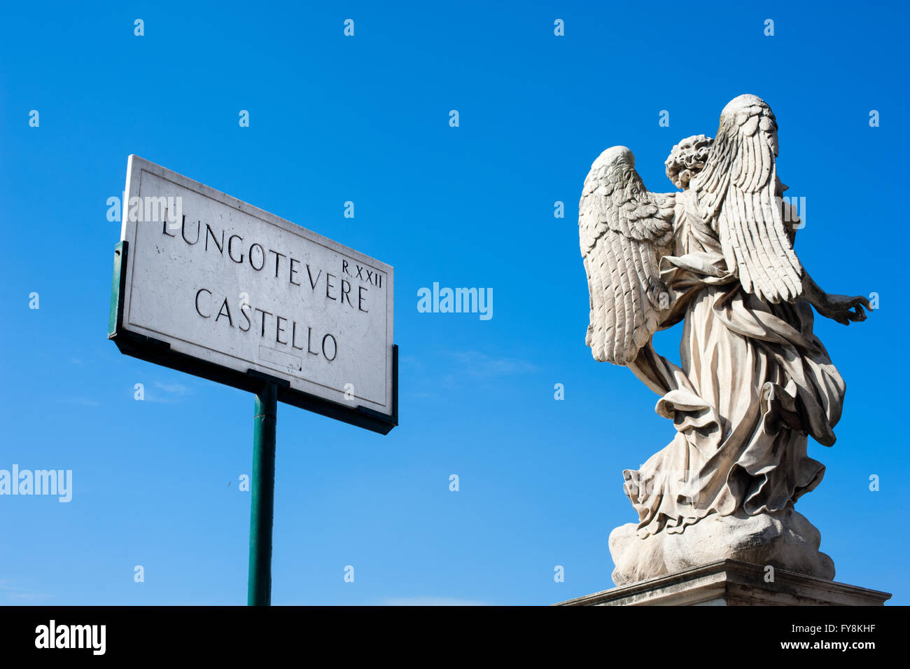 Sant Angelo castle road sign in Roma con angelo antica statua vista da dietro sul cielo blu Foto Stock