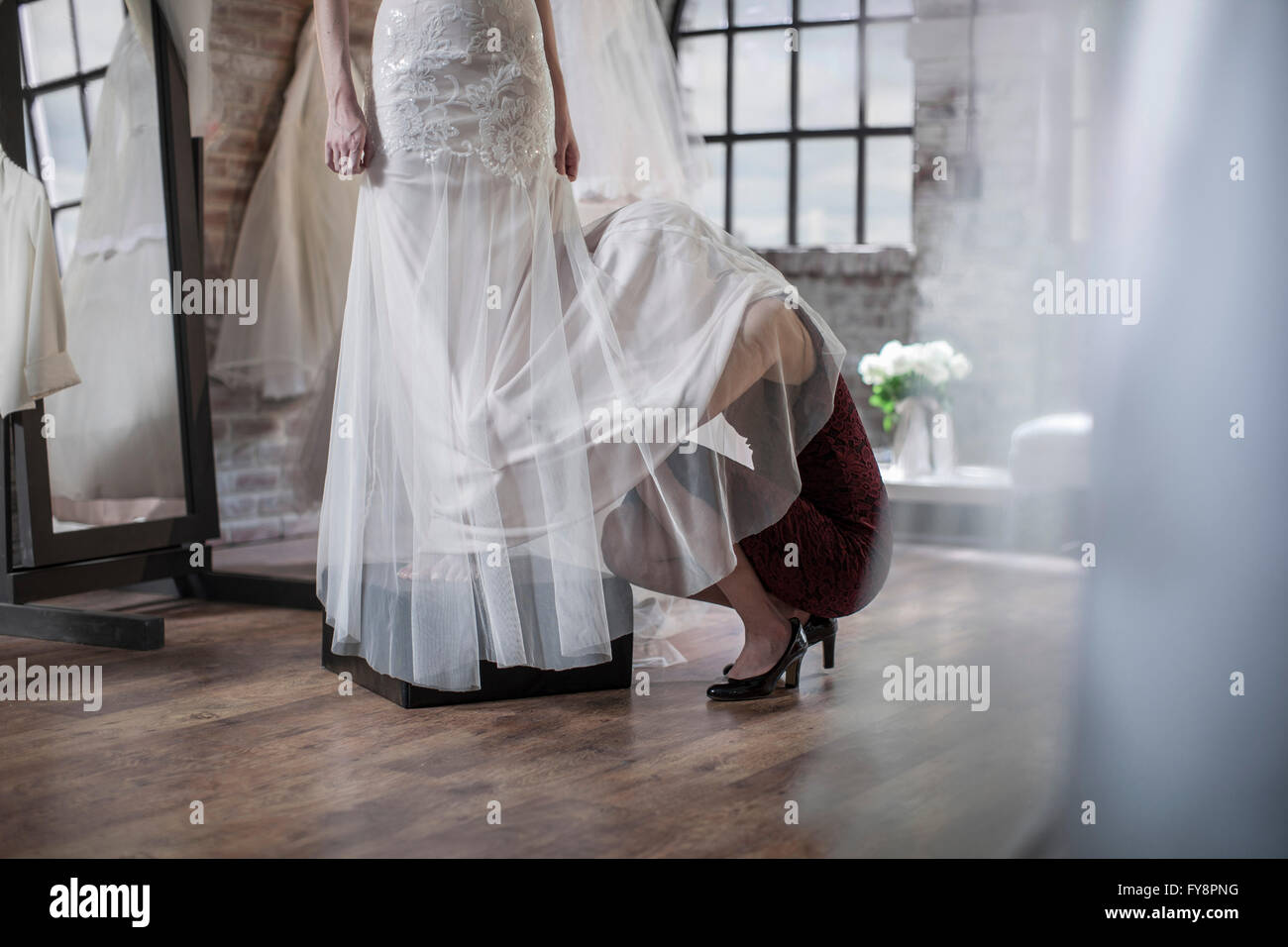 Abito da sposa designer accovacciato sotto abiti da sposa Foto Stock