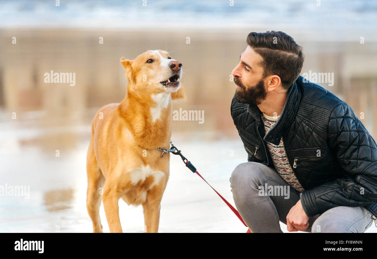 L'uomo guarda il suo cane baying Foto Stock