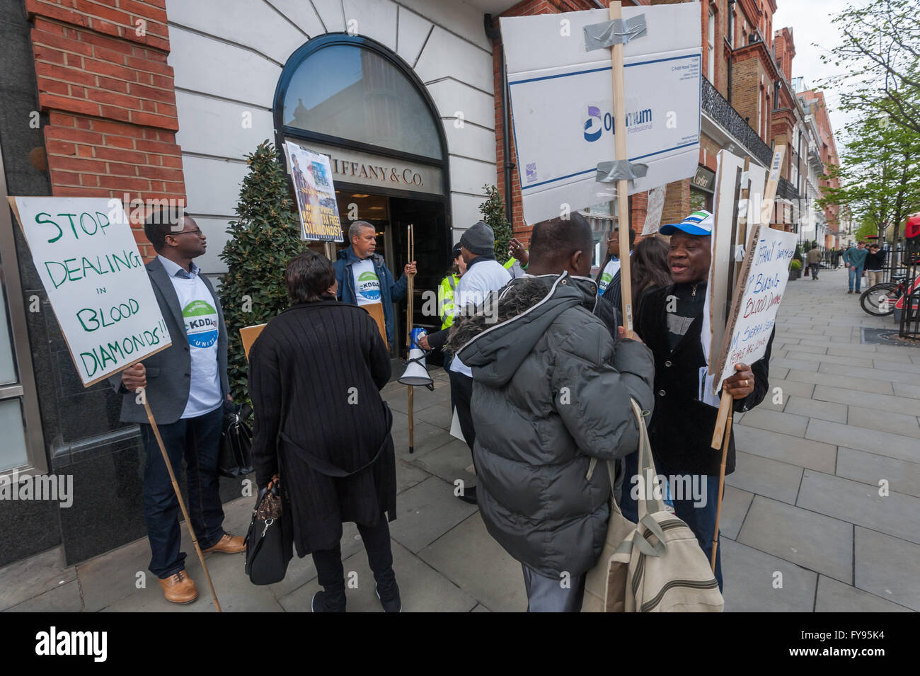 Londra, Regno Unito. 23 Aprile, 2016. Dopo che protestavano davanti a Selfridges, i manifestanti da Kono district in Sierra Leone venite a Sloane Square per dimostrare al di fuori Tiffanys. La polizia ha detto loro che non potevano protestare su un ampio marciapiede vi ma deve attraversare per protestare in un set di penne a parte per loro nella piazza di fronte. Dopo qualche argomento lo hanno fatto in modo, sebbene non sembrava esserci alcuna ragione oltre a quella di attenuare l'impatto della protesta per la polizia per spostarli. Credito: Peter Marshall / Alamy Live News Foto Stock