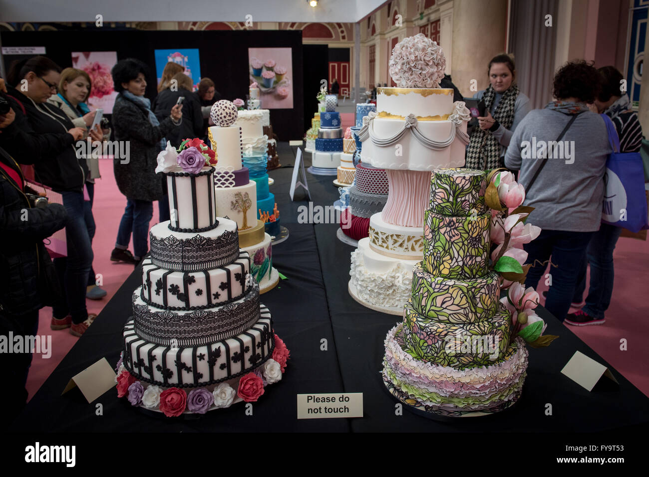 Le persone che ricercano decorativo torte nuziali a Torta International - La Sugarcraft, torta decorazione e cottura mostra a Londra. Foto Stock