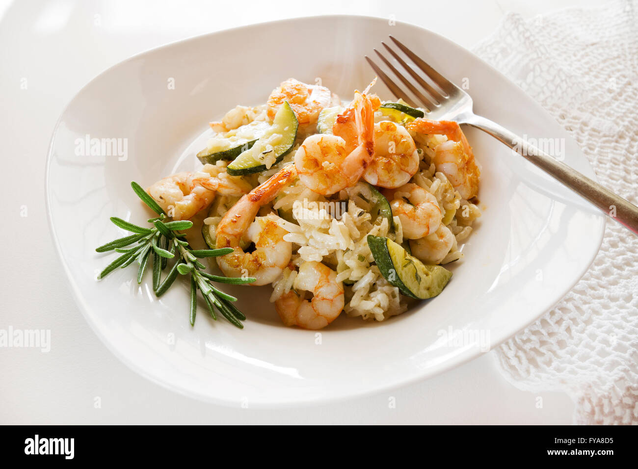 Risotto con scampi freschi e le verdure sul tavolo bianco. Foto Stock