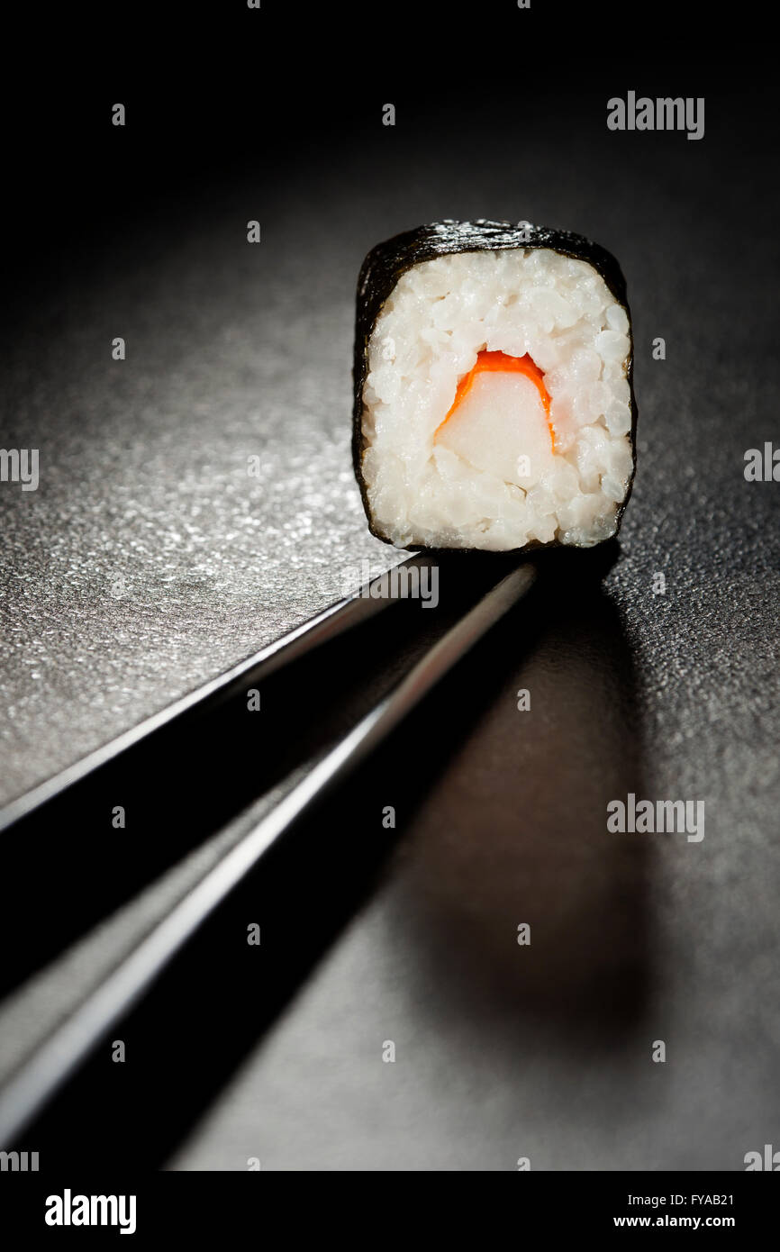 Maki Sushi con surimi, bacchette Foto Stock