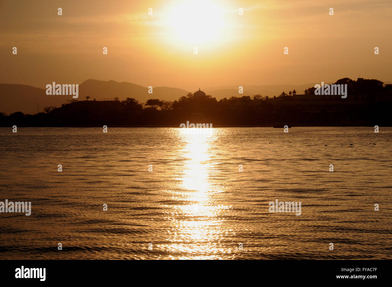 Tramonto sul lago Pichola in cui sorge la città di Udaipur nel Rajasthan, India settentrionale. Foto Stock