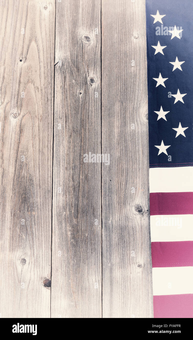 Stati Uniti d'America sbiadita bandiera sul confine rustico verticale di tavole di legno. Effetto Vintage applicato per l'immagine. Foto Stock