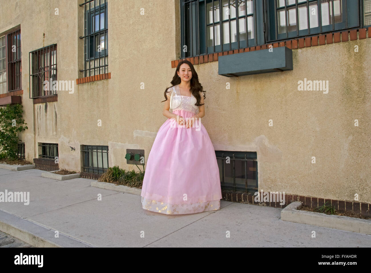 Un bel giovane sposa coreana nella sua rosa abito da sposa in una sessione di foto su Washington Mews nel Greenwich Village di New York City Foto Stock