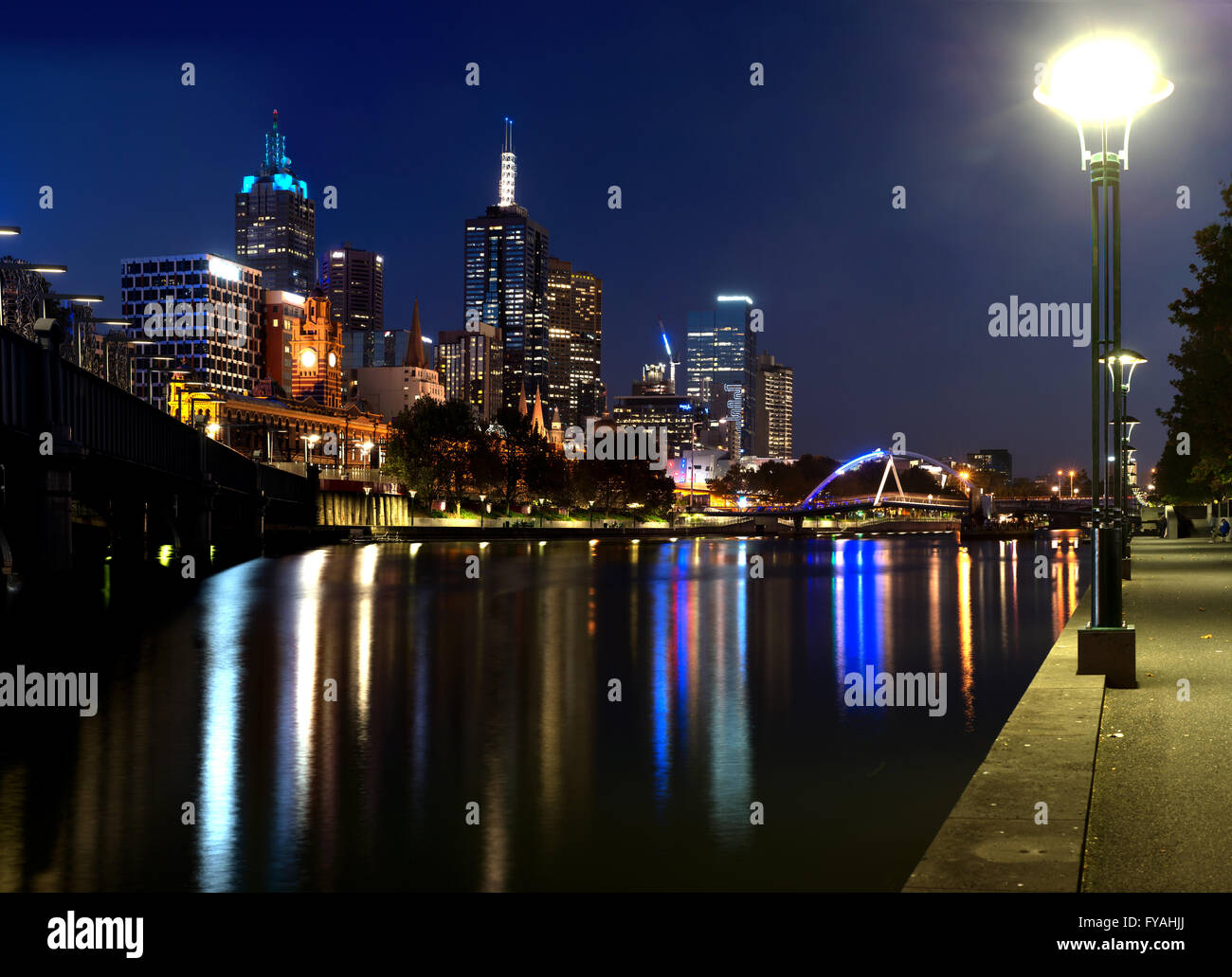 Una panoramica di una foto notturna della città di Melbourne, la stazione di Flinders Street, Ewan Walkers ponte sul fiume Yarra con belle riflessioni. Foto Stock