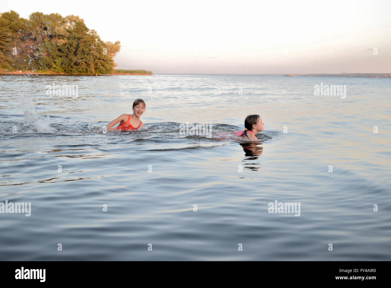 Gli adolescenti nuotare nel fiume Foto Stock