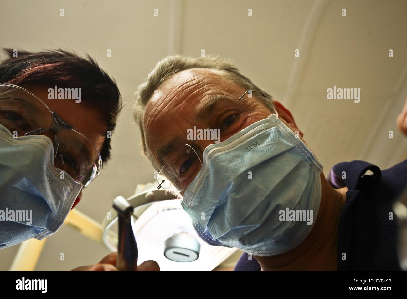 Dentista e assistente con maschera al lavoro dal basso prende le foto. 19/04/2016 Foto Stock