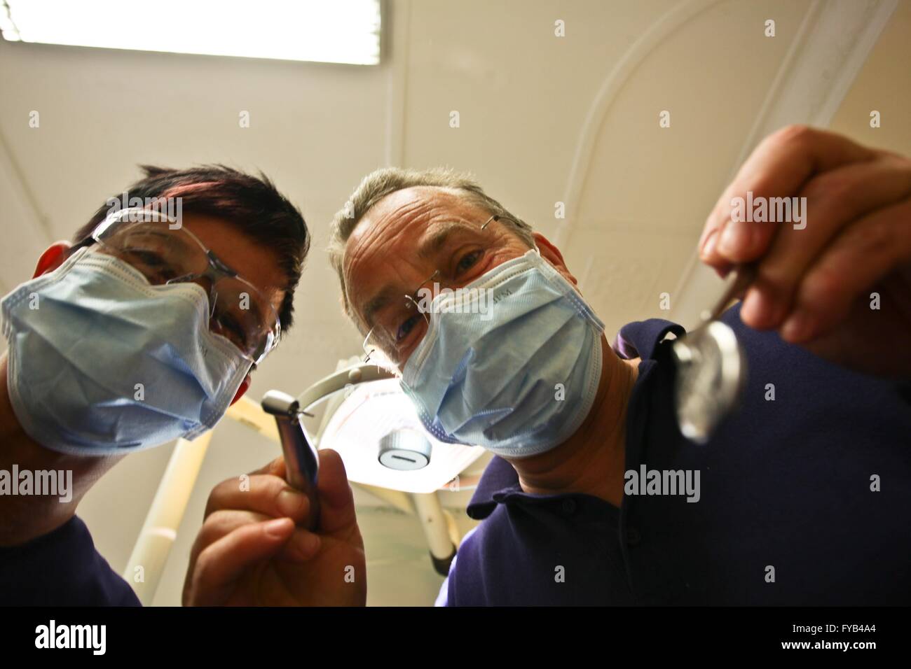 Dentista e assistente con maschera al lavoro dal basso prende le foto. 19/04/2016 Foto Stock