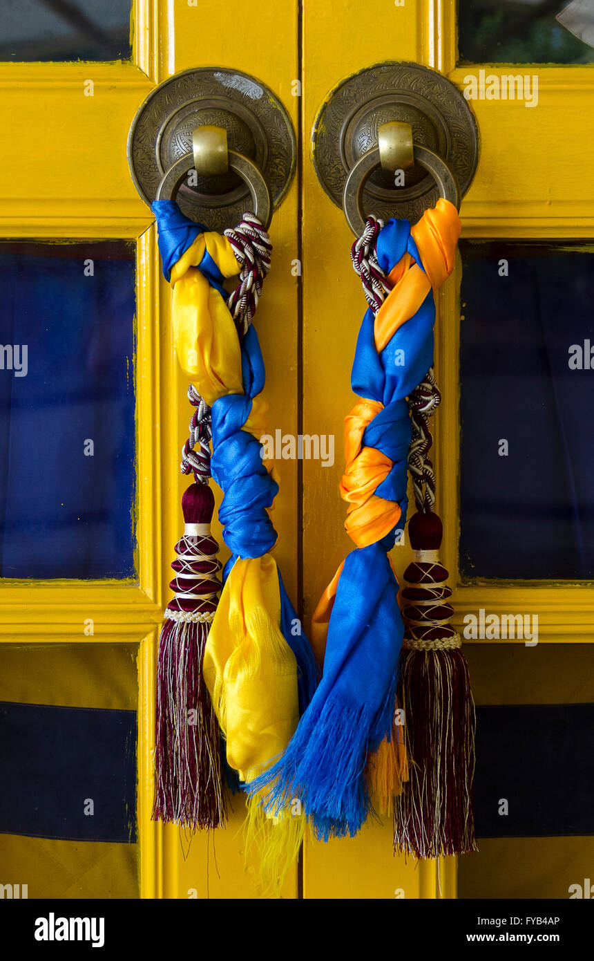 Il blu e il giallo nappe sullo sportello, il Dalai Lama tempio, McLeod Ganj, Dharamshala, Distict Kangra, Himachal Pradesh, India. Foto Stock
