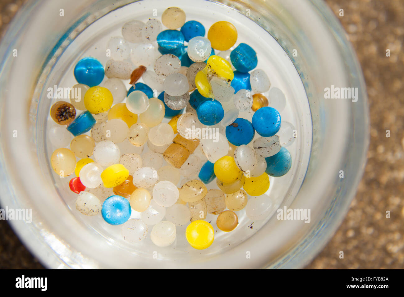 Una raccolta di piccoli nurdles di plastica in un vaso si trovano su una spiaggia scozzese. Foto Stock