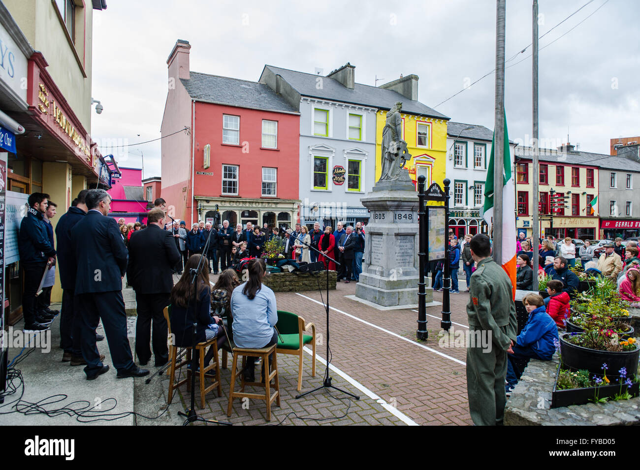 Skibbereen, Irlanda. 24 Aprile, 2016. La folla di circa 200 ascoltare attentamente per altezze di misericordia Scolaro, James O'Sullivan potente versione di orazione che è stata letta su O'Donovan Rossa la sua tomba da Padraig Pearse in O'Donovan Rossa i funerali nel 1915. La lettura è stata parte della scuola del Annuncio evento della durata di un giorno per commemorare i 100 anni dall'inizio della ribellione in Dublino. Credito: Andy Gibson/Alamy Live News Foto Stock