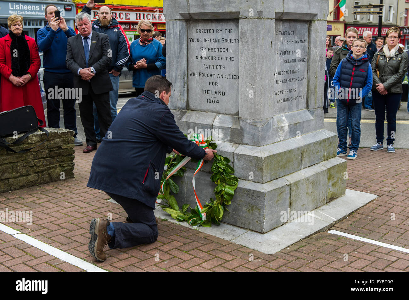 Skibbereen, Irlanda. 24 Aprile, 2016. La Misericordia Heights School Vice Preside stabilisce una corona di fiori alla cameriera di Erin statua durante la misericordia altezze della scuola Annuncio evento della durata di un giorno per commemorare i 100 anni dall'inizio della ribellione in Dublino. Credito: Andy Gibson/Alamy Live News Foto Stock