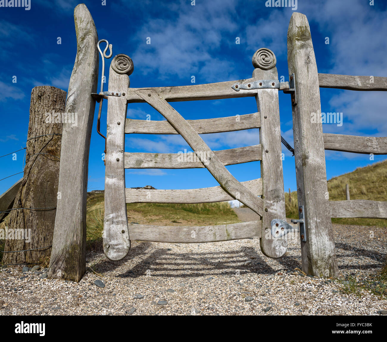 Intagliato a mano porta in legno sul percorso rurale a Ynys Llanddwyn, Newborough, Anglesey, Galles. Foto Stock