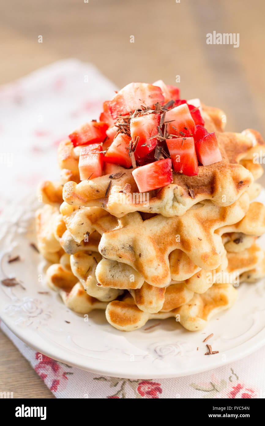 Strawberry waffle per la prima colazione servita sulla piastra bianca. Morbida luce mattutina, tonica immagine Foto Stock