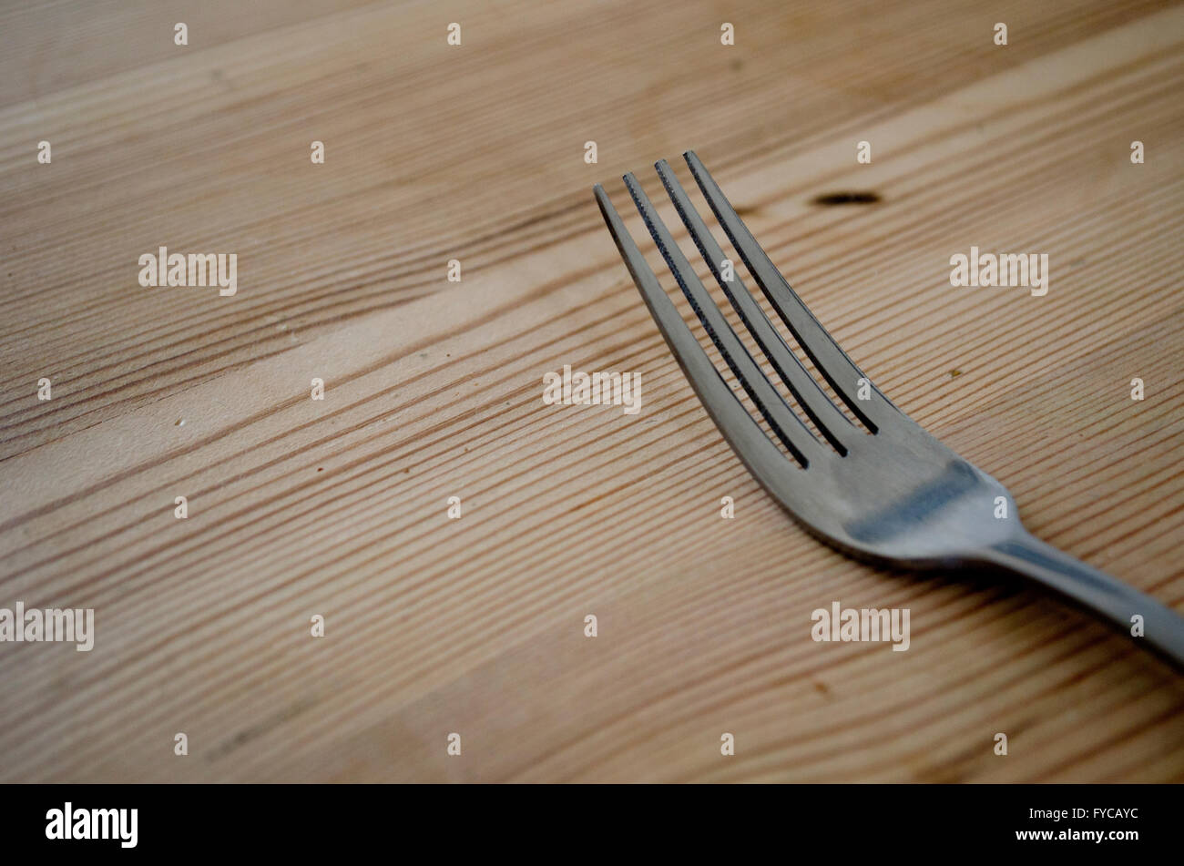 Forchetta su un tavolo da pranzo in legno Foto Stock