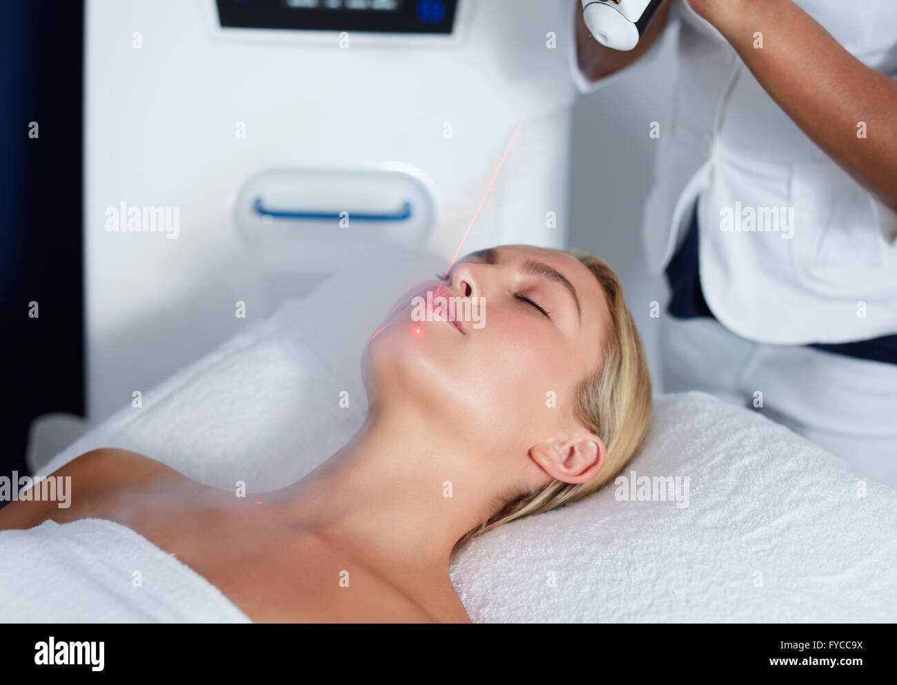 Attraente giovane donna ottenendo la crioterapia locale terapia in cosmetologia clinica. Applicazione di freddo i vapori di azoto alla faccia di wom Foto Stock