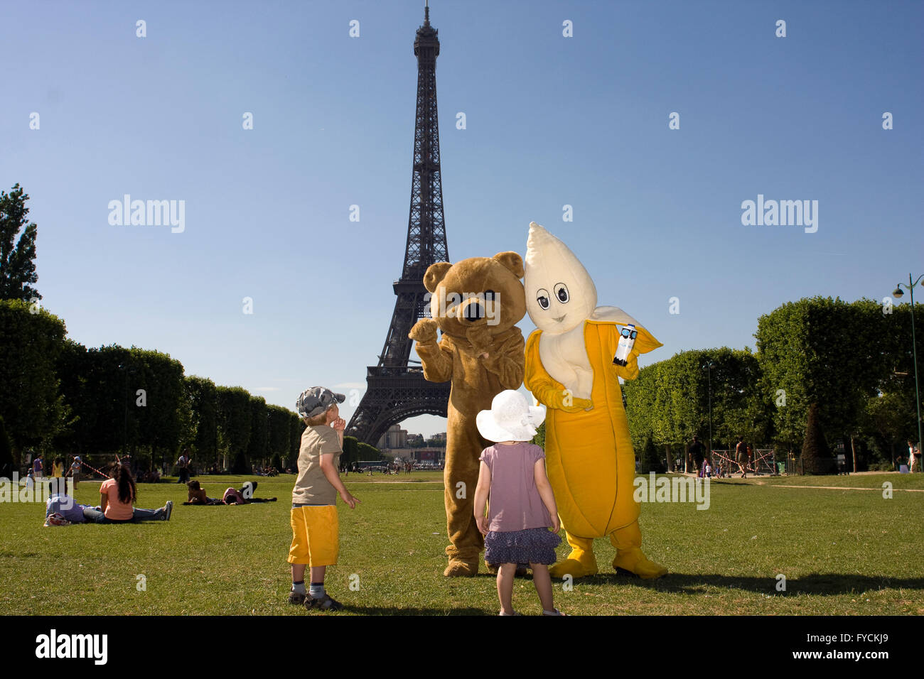 I bambini di ottenere l'attrazione di un giovane che indossa un abito di fantasia nella Torre Eiffel. Foto Stock