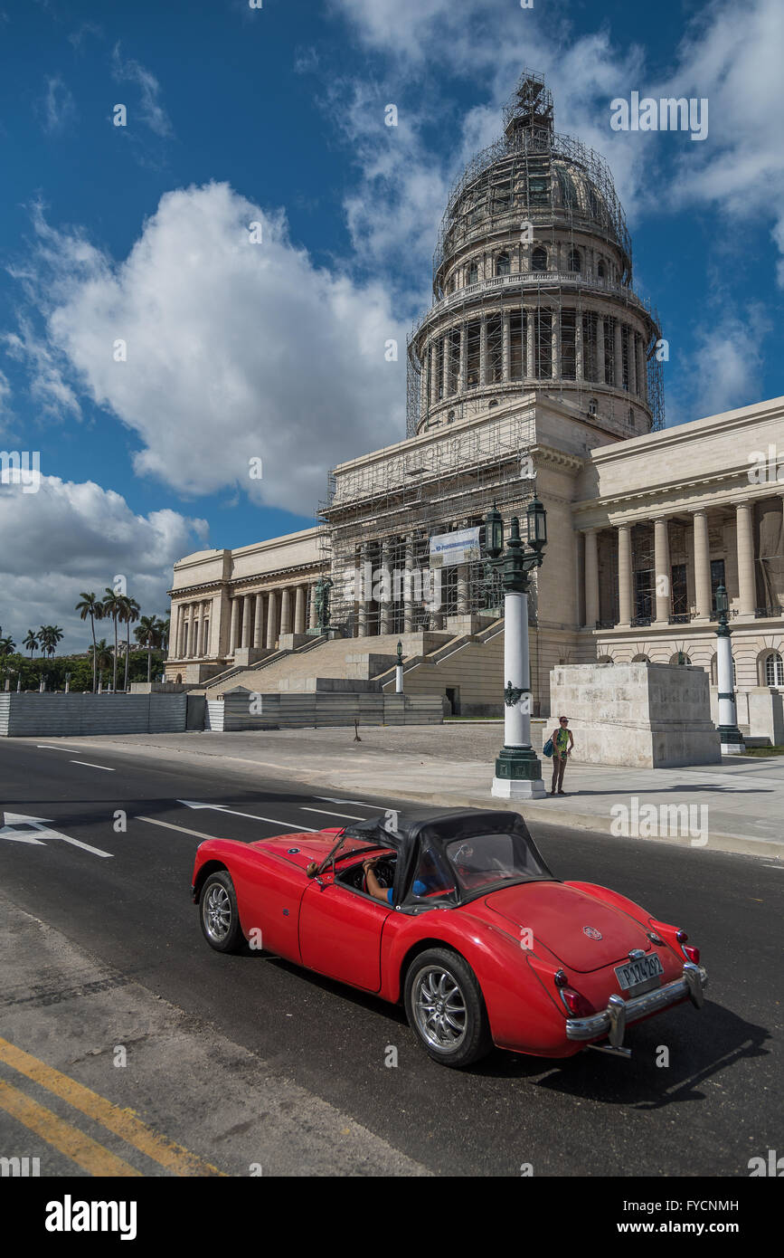 Un rosso classico MG auto sportiva passa davanti al National Capitol Building (Capitolio Nacional), Havana (La Habana) Cuba Foto Stock