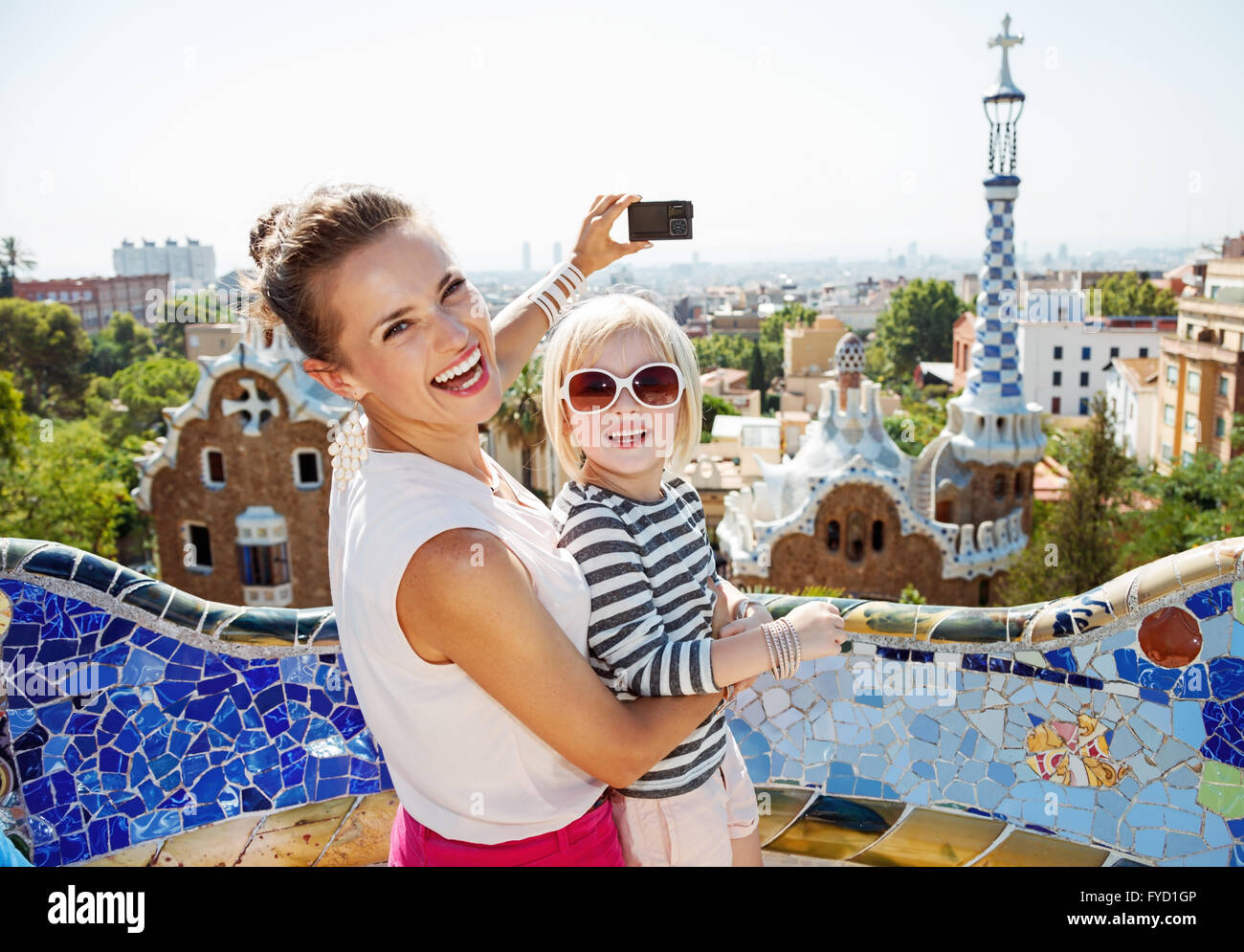 Barcellona vi mostrerà come notevolmente trascorrere le vacanze. Sorridendo il bambino e la madre di scattare le foto con una fotocamera digitale a Park Guell Foto Stock